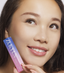 Beautiful woman applying her own lash extensions at home