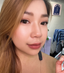 Beautiful woman applying her own lash extensions at home