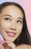 Woman with monolid eyes applying at-home DIY eyelash extensions