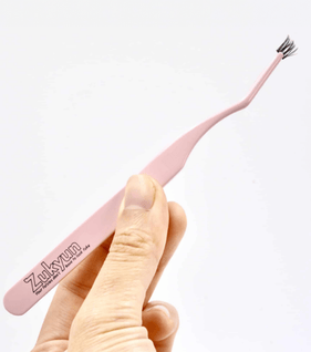 Asian woman applying natural looking fake lashes