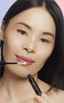 Asian woman applying natural looking fake lashes 