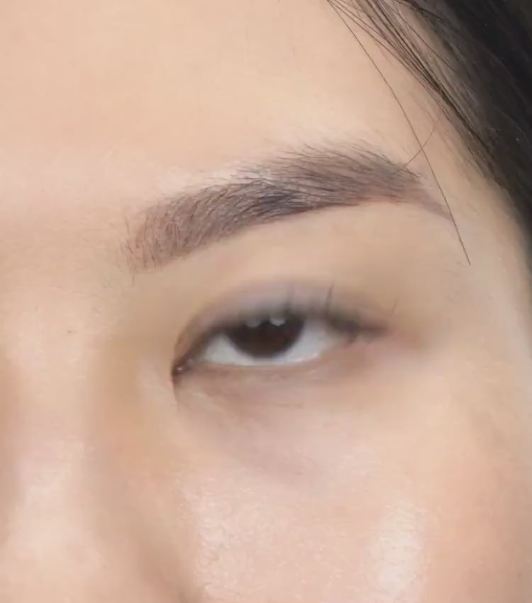 Beautiful woman applying her own lash extensions at home