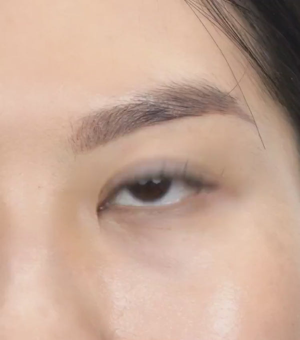 Beautiful woman applying her own lash extensions at home