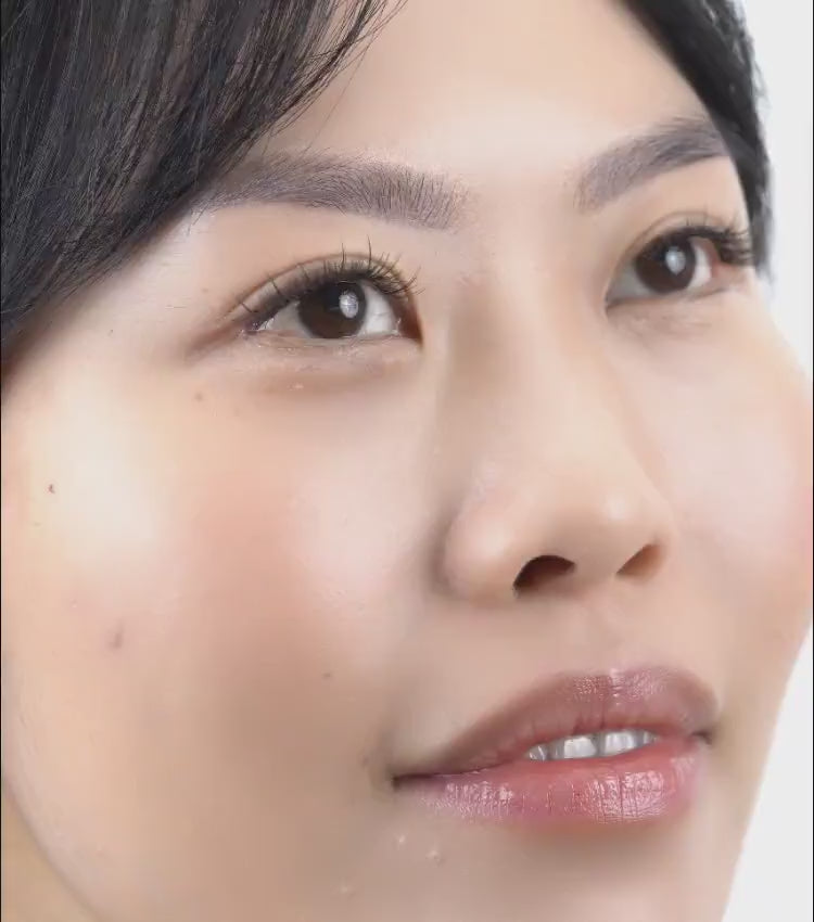 Beautiful woman applying her own lash extensions at home