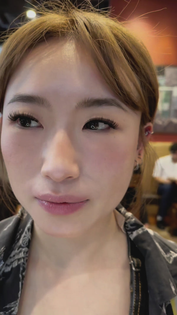 asian woman wearing lashes she applied herself at home
