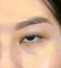 Beautiful woman applying her own lash extensions at home