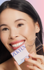 Woman with monolid eyes applying at-home DIY eyelash extensions